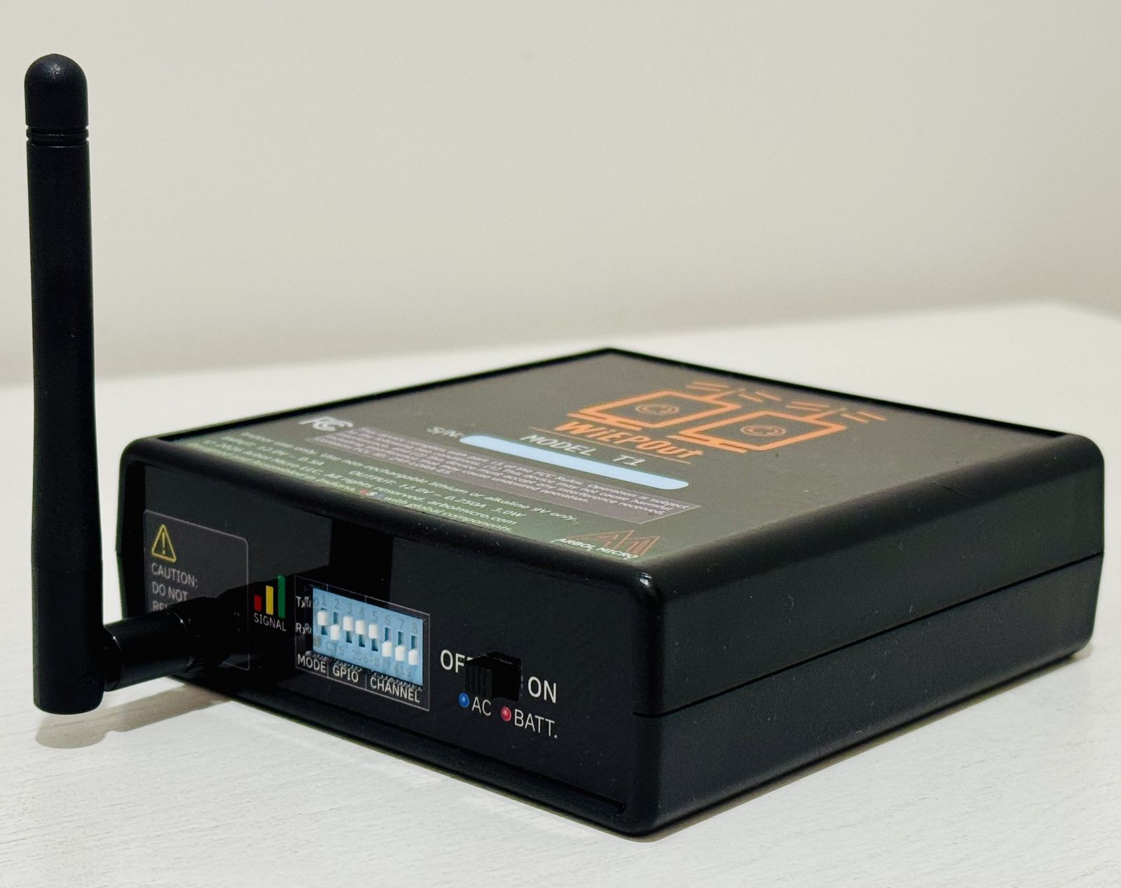 WiEPOut T1 wireless I/O bridge, front 45° view with antenna, signal LEDs and DIP switches
